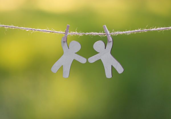 two paper figures clipped on a clothes line